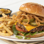 A classic Oklahoma Fried Onion Burger with caramelized onions pressed into a thin beef patty, topped with cheese and served on a toasted bun.